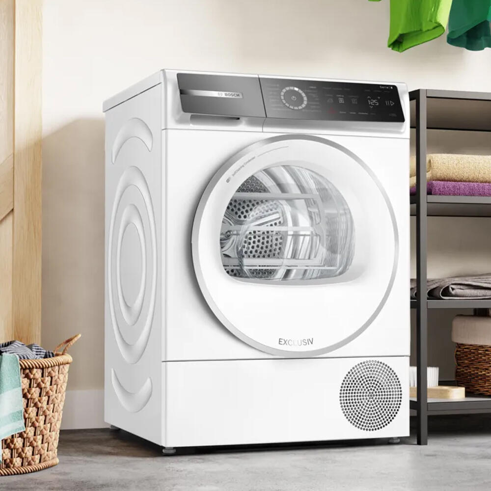 Witte wasmachine op een zachte groenachtige achtergrond.