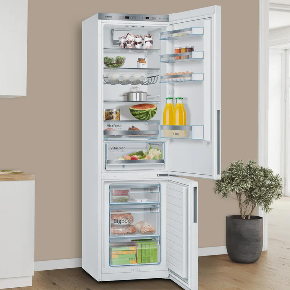 Een openstaande koelkast met verschillende planken en laden, gevuld met diverse voedingsmiddelen.