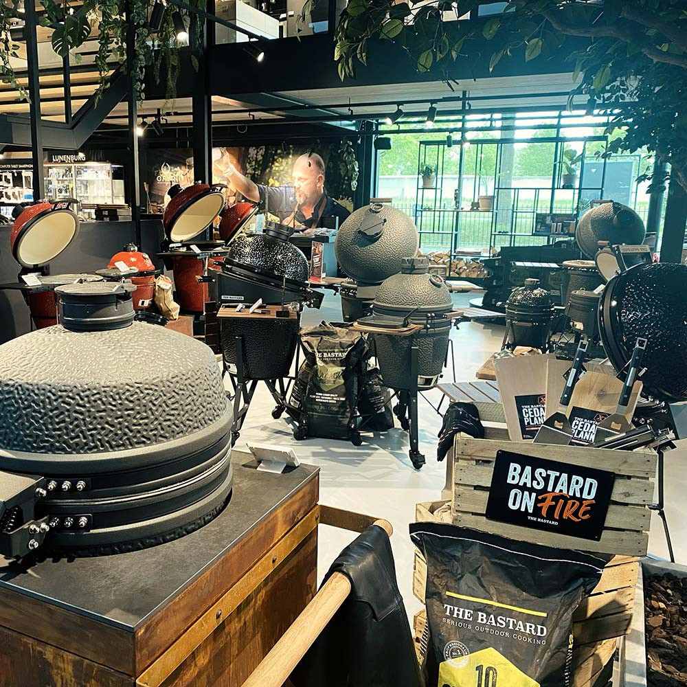 Kamado barbecues en accessoires in een showroom met een bordje "Bastard On Fire".