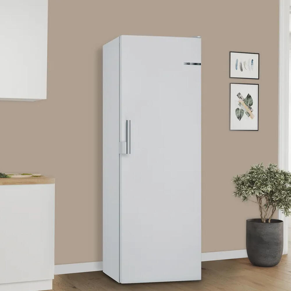 Een witte koelkast in een keuken met planten en muurdecoratie.