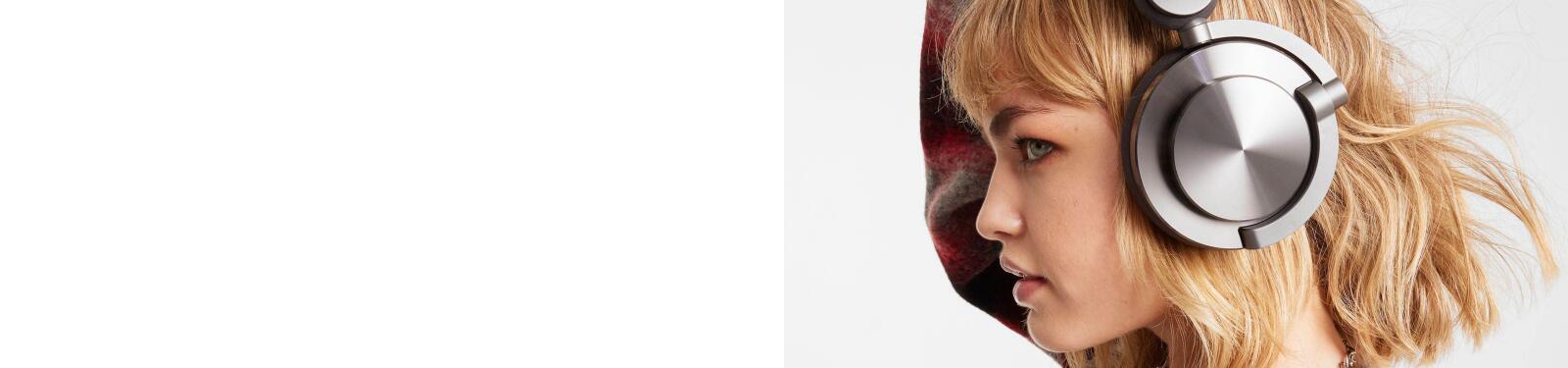 Jong persoon met koptelefoon op, kijkt naar rechts. Achtergrond is wit.