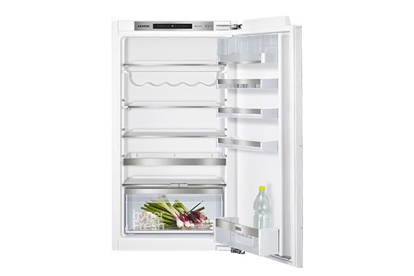 Openstaande, lege koelkast met enkele groente in de lade en een fles op de deurplank.