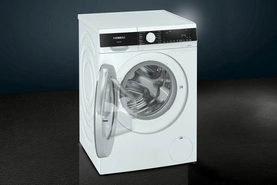 Wasmachine met open deur, witte kleur, op een donkere achtergrond.